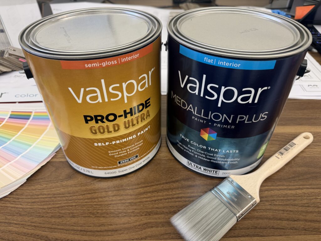 two paint cans with a paintbrush